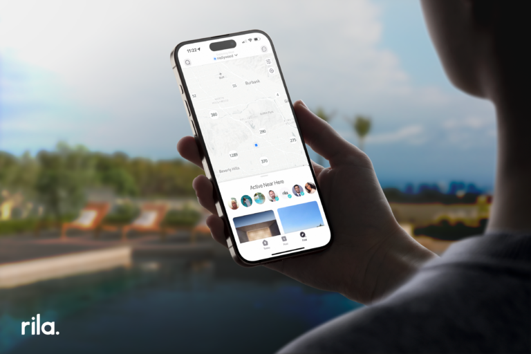 Person holding a smartphone with Rila app open, displaying an interactive map of local real estate listings, symbolizing efficient house hunting in a digital age.