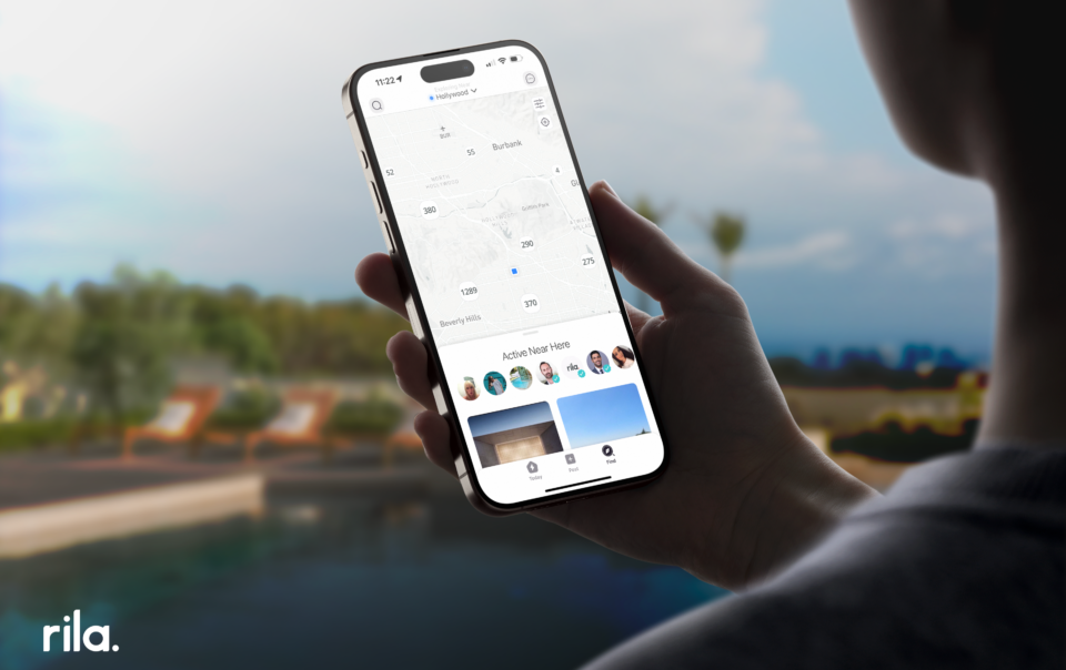 Person holding a smartphone with Rila app open, displaying an interactive map of local real estate listings, symbolizing efficient house hunting in a digital age.